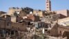 Menara masjid berdiri di belakang rumah-rumah yang rusak atau hancur akibat gempa bumi di Moulay Brahim, Provinsi Al-Haouz, pada 9 September 2023. (Foto: AFP)