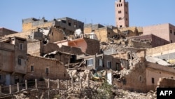 Menara masjid berdiri di belakang rumah-rumah yang rusak atau hancur akibat gempa bumi di Moulay Brahim, Provinsi Al-Haouz, pada 9 September 2023. (Foto: AFP)