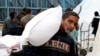 Un niño carga una bolsa de harina distribuida por la Agencia de Naciones Unidas para los Refugiados Palestinos (UNRWA), en medio del conflicto en curso entre Israel y Hamás, en Rafah, en el sur de la Franja de Gaza, el 29 de enero de 2024.