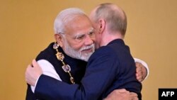 Президент Росії Володимир Путін нагороджує прем'єр-міністра Індії Нарендру Моді орденом святого апостола Андрія Первозванного під час церемонії після їх переговорів у Кремлі в Москві, 9 липня 2024. Фото Олександра НЕМЕНОВА / AFP