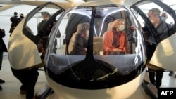 Florian Reuter (kanan), CEO Volocopter GmbH menjelaskan prototip taksi udara "volocopter" kepada dua orang tamunya.
