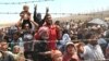 Syrian refugees, flee intense fighting in northern Syria between Kurdish fighters and Islamic State militants, are seen massed at the Turkish border in Akcakale, southeastern Turkey, June 15, 2015.