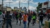 Sejumlah demonstran berlari setelah polisi menembakkan gas air mata untuk membubarkan aksi massa yang menuntut pengunduran diri Perdana Menteri Haiti Ariel Henry di Port-au-Prince, Haiti, pada 10 Oktober 2022. (Foto: AP/Odelyn Joseph)