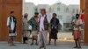 Armed men loyal to Yemen President Abd-Rabbu Mansour Hadi stand guard outside a local authority compound after taking it over in Yemen's southern port city of Aden, Feb. 16, 2015.