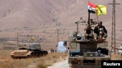 Bendera Hizbullah dan Suriah berkibar di atas kendaraan militer di Qalamoun Barat, Suriah, 28 Agustus 2017. (Foto: Reuters)
​