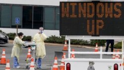 Trabajadores de salud en Arlington, Virginia, esperan conductores en un punto móvil de pruebas de detección del coronavirus, el 19 de marzo de 2020.