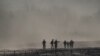Un grupo de migrantes es detenido por miembros de la Guardia Nacional de Estados Unidos en Eagle Pass, Texas, visto desde Piedras Negras, México.