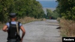 FILE - A red flag attached to a pro-Russian separatist tank is seen near a checkpoint near the town of Slovyanoserbsk, Luhansk region, eastern Ukraine, Sept.10, 2014..