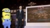 环球主题乐园及度假村集团主席、首席执行官汤姆•威廉姆斯在北京公布了主题公园的未来展示图后，和卡通电影人物小黄人(Minion)站在一起。（2014年10月13日）