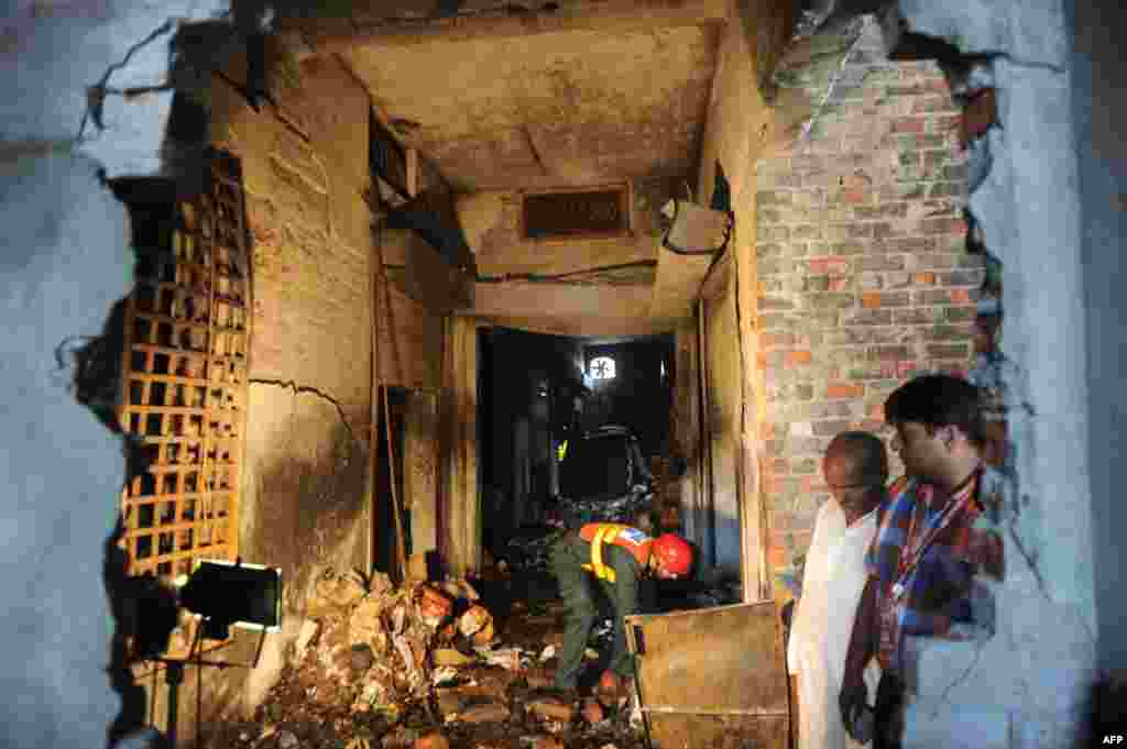 Pakistani rescuers collect evidence in a shoe-making factory following a fire which gutted the factory the previous night in Lahore, September 12, 2012.