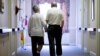 FILE - Decima Assise, who has Alzheimer's disease, and Harry Lomping walk the halls at The Easton Home in Easton, Pennsylvania, Nov. 6, 2015.
