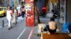 Pedestrians pass by a homeless man in the Monastiraki area of central Athens, Greece, June 24, 2015.