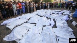 Para pelayat menggelar salat jenazah di Rumah Sakit Shuhada Al-Aqsa untuk para korban serangan udara Israel di Deir Balah, di tengah Jalur Gaza, 6 November 2023. (Foto: Mahmud Hams/ AFP)