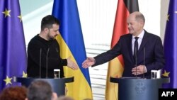 Канцлер Німеччини Олаф Шольц простягає руку президенту України Володимиру Зеленському після пресконференції в Берліні, 16 лютого 2024 р. Україна та Німеччина підписали угоду про безпеку, яку канцлер Олаф Шольц назвав "історичним кроком". (Фото Джона МАКДУГАЛЛА / AFP)