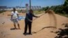 Abdelkrim Naaman, the chairman of the NGO Nalsya, right, advises a farmer on seeding, irrigation and drought mitigation, on a farm on the outskirts of Kenitra, Morocco, June 21, 2024.