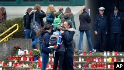 Düşen uçaktaki ölen Alman lise öğrencilerinin arkadaşları okul binası önünde kucaklaşırken