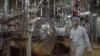 FILE - Wearing protective clothes, an Iranian security person walks through the Uranium Conversion Facility just outside the city of Isfahan, Iran, in March 2005. 