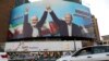 FILE - Vehicles drive past a huge banner showing the late Hamas leader Ismail Haniyeh, left, who was killed in an assassination last week, joining hands with Iranian President Masoud Pezeshkian, in a square in downtown Tehran, Iran, Aug. 5, 2024. 