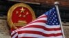 FILE - The U.S. flag is flown next to the Chinese national emblem in Beijing, Nov. 9, 2017. A Chinese American man was convicted on Aug. 6, 2024, for gathering information on Chinese dissidents in the United States and giving it to China.