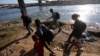 Migrantes caminan a lo largo de las orillas del río Grande antes de cruzar en un intento de buscar asilo en Estados Unidos, visto desde Piedras Negras, México, el 29 de septiembre de 2023. 