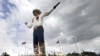 FILE - Bluebonnets, the state flower of Texas, surround Big Tex as storm clouds move in above, Sept. 27, 2013, in Dallas. 