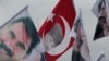 Supporters of the pro-Kurdish Peoples' Democratic Party, (HDP) wave a flag, center, with Turkish Republic founder Mustafa Kemal Ataturk, and others of imprisoned Kurdish rebel leader Abdullah Ocalan, during a rally in Istanbul, Turkey.