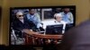 Khieu Samphan, second from right, former Khmer Rouge head of state, and Noun Chea, left, who was the Khmer Rouge's chief ideologist and No. 2 leader, is seen on a screen at the court's press center of the U.N.-backed war crimes tribunal in Phnom Penh, Cambodia.