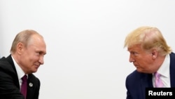 На фото: президент США Дональд Трамп та президент Росії Володимир Путін спілкуються під час саміту G20 у Японії у червні 2019-го року
