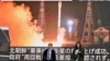 Pejalan kaki berjalan melewati layar yang menampilkan peluncuran satelit pengintai Korea Utara 'Malligyong-1', di distrik Akihabara Tokyo pada 22 November 2023. (Foto: AFP)