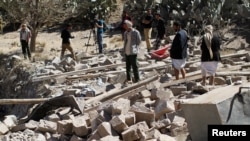FILE - People walk on the rubble of a house destroyed by a Saudi-led airstrike in Sana'a, Yemen, Feb. 2, 2017. 