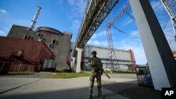 Seorang prajurit Rusia menjaga area PLTN Zaporizhzhia yang berada di wilayah di bawah kendali militer Rusia, Ukraina tenggara, 1 Mei 2022. (Foto: AP)