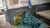 Une Mozambicaine est allongée dans un lit d'hôpital avec son nouveau-né dans la maternité Murrupelane de Nacala, dans la province de Nampula, au Mozambique, le 5 juillet 2018.