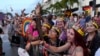 People watch as floats pass by during the Stonewall Pride Parade and Street Festival, June 17, 2023, in Wilton Manors, Fla.