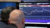 FILE - A pair of specialists study a screen at a post on the floor of the New York Stock Exchange, Oct. 5, 2016.