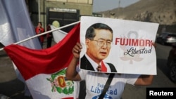 FILE: Seorang pengikut Presiden Peru Alberto Fujimori berdiri di luar penjara dengan memegang plakat, setelah pengadilan tinggi mengembalikan pengampunan Fujimori, di Lima, Peru, 29 November 2023. (REUTERS/Sebastian Castaneda)