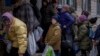 Sergei, 11, mengantre giliran untuk mendapatkan bantuan makanan yang didistribusikan di Bucha, pinggiran Kota Kyiv, Ukraina, pada 19 April 2022. (Foto: AP/Emilio Morenatti)