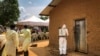 Un employé de l'Organisation mondiale de la santé décontamine l'entrée d'une maison située dans une parcelle où deux cas d'Ebola ont été découverts, dans le village de Mabalako, dans l'est du Congo, le 17 juin 2019.