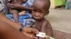 FILE - A doctor attends to a malnourished child at a refugee camp in Yola, Nigeria. The number of people worldwide in need of humanitarian assistance has soared to a record-breaking 130 million, U.N. figures show.