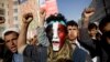 FILE - A Houthi Shi'ite rebel with Yemen's flag painted on his face chants slogans during a rally in the capital, Sana'a, Yemen.