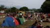 ARCHIVO: Migrantes en una caravana que viaja por México hacia la frontera con EEUU descansan en una plaza pública de Mapastepec, el 29 de diciembre de 2023.