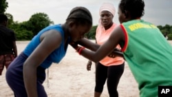 Coach Isabelle Sambou, 43 , two-time Olympian and nine-time African wrestling champion, center, explains moves to young women during a wrestling training, in Mlomp, southern Senegal, July 10, 2024. 