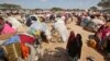 Drought-stricken Somalis walk through a camp in the Garasbaley area on the outskirts of Mogadishu, Somalia, March 28, 2017. 