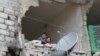 FILE - Children peer from a partially destroyed home in Aleppo, Syria. 