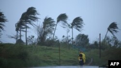 Seorang pengendara kendaraan bermotor melewati jalan di tengah angin kencang yang dipicu oleh Badai Tropis Vamco di Kota Legazpi, provinsi Albay, Filipina, 11 November 2020. 