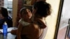 FILE - Ericka Torres holds her 3-month-old son, Jesus, who was born with microcephaly, at their home in Guarenas, Venezuela, Oct. 5, 2016. 