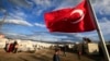 FILE - A Turkish flag flies at the refugee camp for Syrian refugees in Islahiye, Gaziantep province, southeastern Turkey, March 16, 2016. 