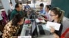 Locals, left, sit for registering their names during a voter registration process of the National Election Committee (NEC) in Phnom Penh, Cambodia, Thursday, Sept. 1, 2016. 
