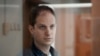 FILE - Reporter Wall Street Journal Evan Gershkovich berdiri di dalam sangkar kaca di ruang sidang Pengadilan Kota Moskow di Moskow, Rusia, 10 Oktober 2023. Pengadilan memutuskan untuk memperpanjang penahanan Gershkovich hingga 30 Januari.(AP Photo/Alexander Zemlianichenko, File)