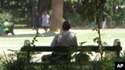 FILE - A man sits on a bench in a park in Harare, Zimbabwe, March 26, 2014. Zimbabwe has taken a new approach to addressing mental health issues by installing 'friendship benches' for counseling sessions.
