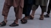 FILE - Recaptured Afghan prisoners walk in leg chains in jail in Kandahar, Afghanistan, April 26, 2011.
